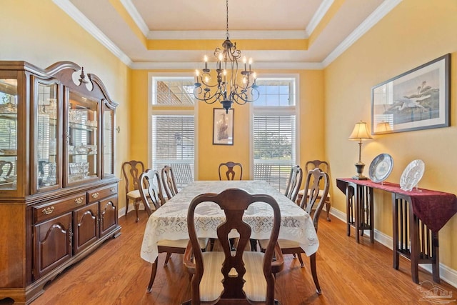 dining room with ornamental molding, light wood-type flooring, and an inviting chandelier