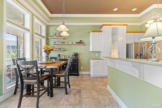 dining room with a raised ceiling and crown molding