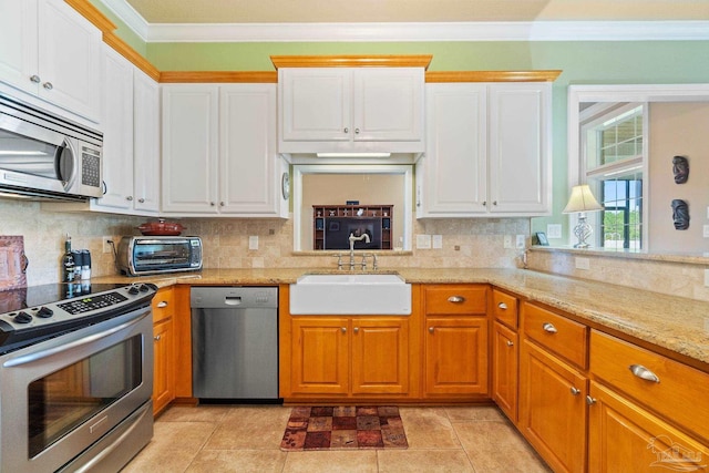 kitchen featuring decorative backsplash, appliances with stainless steel finishes, light tile patterned floors, and sink