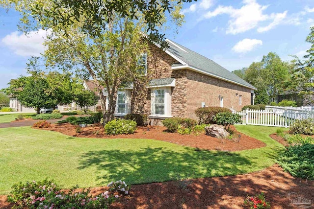 view of side of home with a lawn