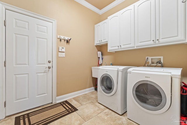 washroom with light tile patterned floors, ornamental molding, washing machine and clothes dryer, and cabinets