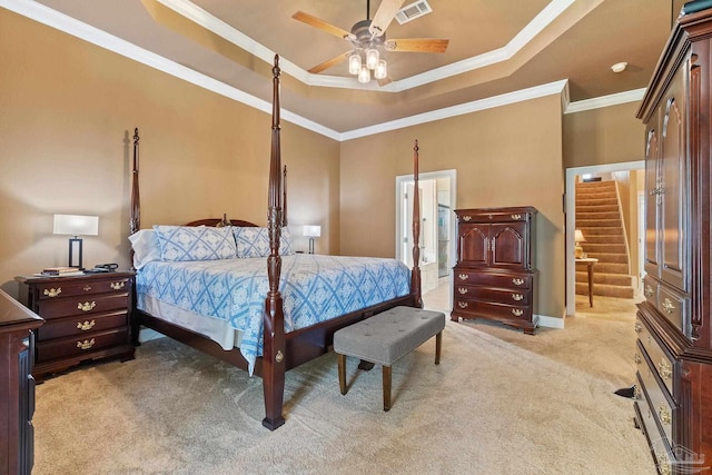 carpeted bedroom featuring ceiling fan, a raised ceiling, crown molding, and ensuite bathroom