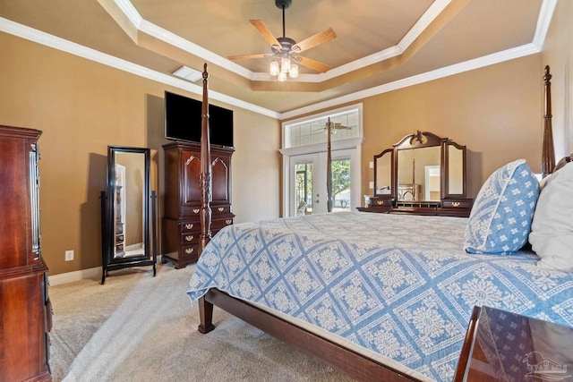 carpeted bedroom featuring ceiling fan, a tray ceiling, crown molding, and french doors