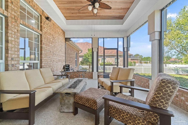 sunroom with wooden ceiling, a raised ceiling, and ceiling fan