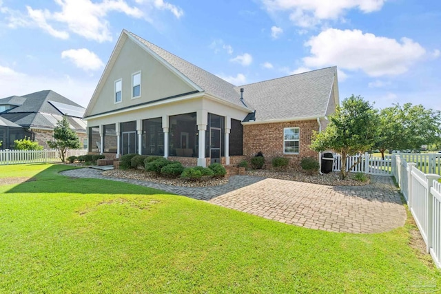 back of house with a sunroom, a patio, and a yard