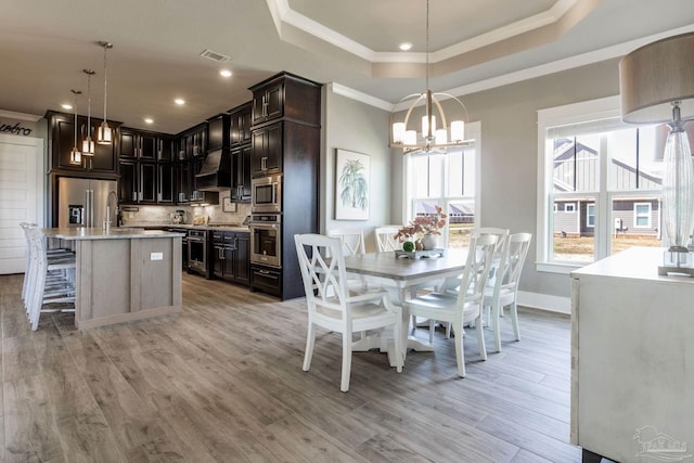 2420 Meeting St, Cantonment, FL 32533 - dining area with a notable chandelier, light wood-type flooring, ornamental molding, visible vents, and a tray ceiling