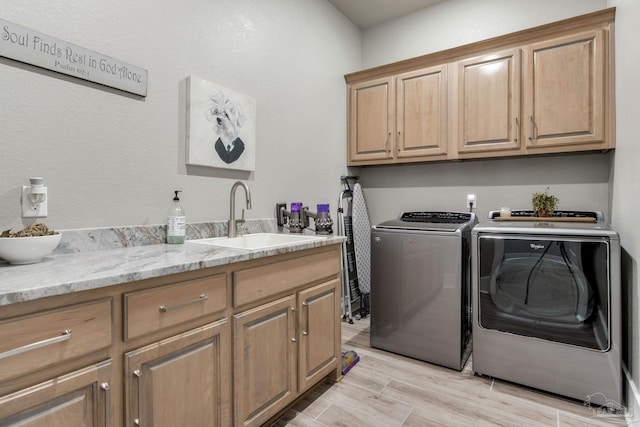 2420 Meeting St, Cantonment, FL 32533 - washroom with cabinet space, light wood-style flooring, a sink, and independent washer and dryer