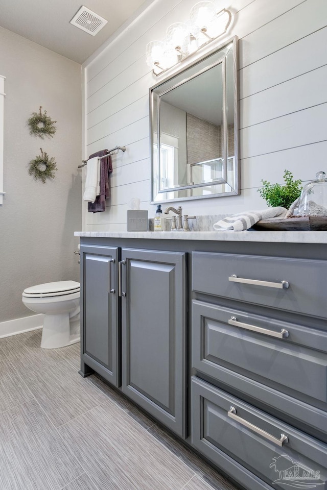 2420 Meeting St, Cantonment, FL 32533 - bathroom featuring wood walls, vanity, visible vents, and toilet