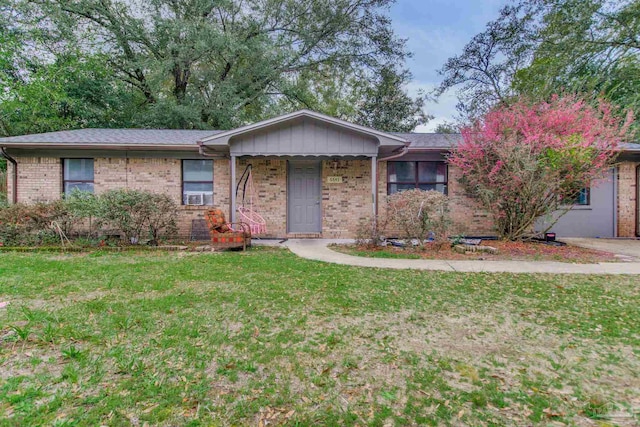 ranch-style house with cooling unit, brick siding, and a front yard