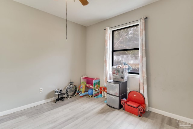 playroom with baseboards, wood finished floors, and a ceiling fan