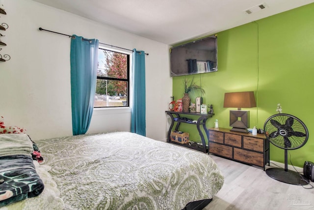 bedroom featuring visible vents and wood finished floors