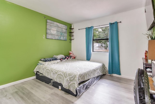 bedroom featuring wood finished floors and baseboards