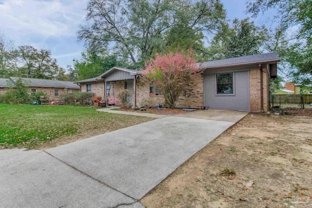 ranch-style home featuring a front lawn, fence, and brick siding