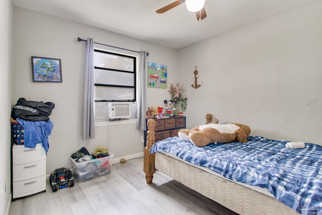 bedroom featuring a ceiling fan, cooling unit, wood finished floors, and baseboards