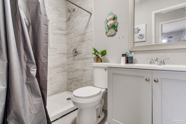 full bathroom with toilet, vanity, and a tile shower