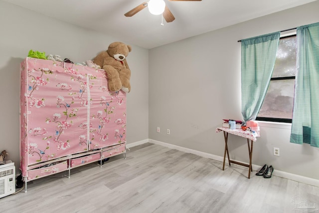 bedroom featuring a ceiling fan, baseboards, and wood finished floors