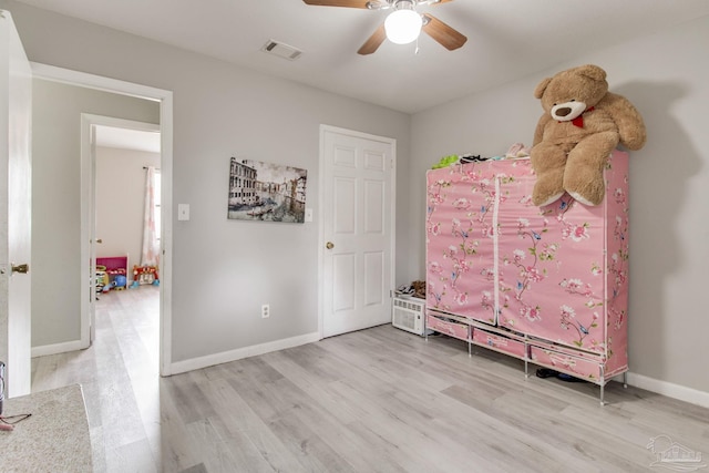 bedroom featuring light wood-style flooring, visible vents, baseboards, and ceiling fan