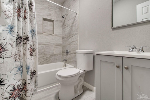 bathroom with toilet, shower / bath combo, baseboards, vanity, and a textured wall