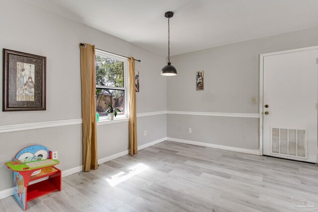 unfurnished dining area featuring wood finished floors, visible vents, and baseboards