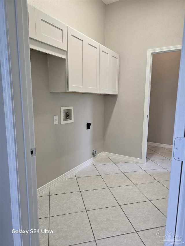 clothes washing area featuring cabinets, washer hookup, electric dryer hookup, and light tile patterned flooring