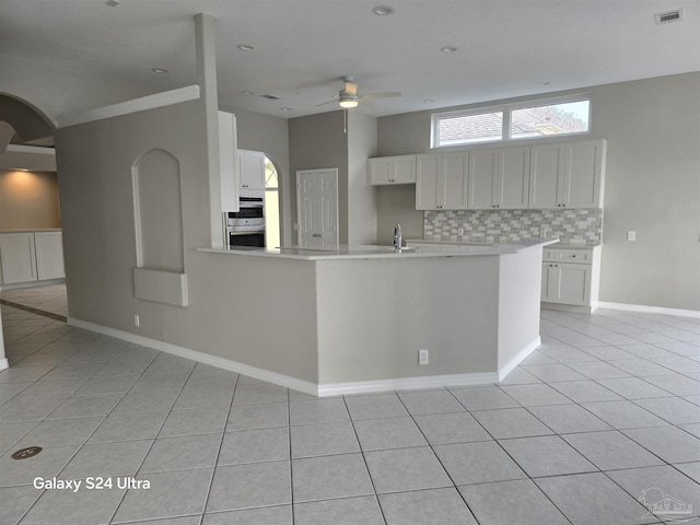 kitchen with backsplash, ceiling fan, sink, white cabinetry, and light tile patterned flooring