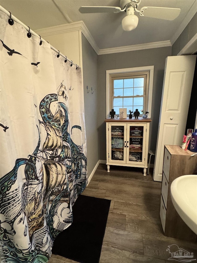 bathroom featuring hardwood / wood-style floors, crown molding, sink, and ceiling fan