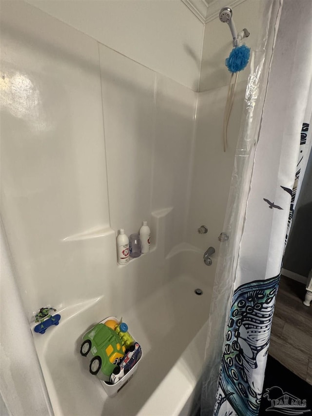 bathroom with wood-type flooring and shower / bath combo