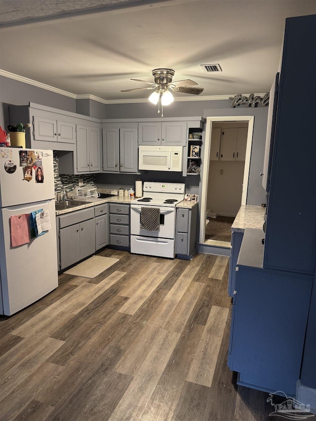 kitchen with white appliances, ornamental molding, dark hardwood / wood-style floors, and ceiling fan