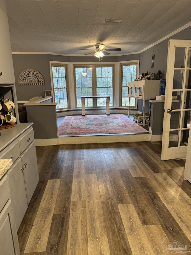 unfurnished bedroom featuring multiple windows, crown molding, and hardwood / wood-style floors