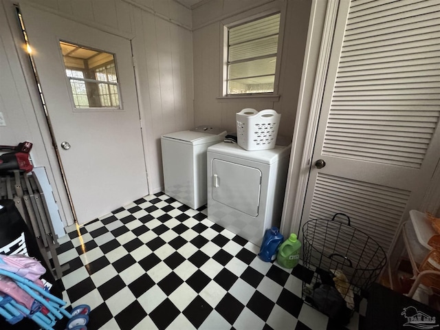 laundry area with washer and dryer and wood walls