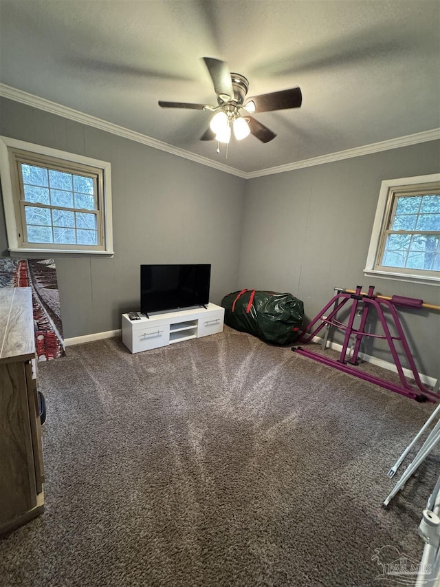 recreation room featuring crown molding, carpet flooring, a wealth of natural light, and ceiling fan