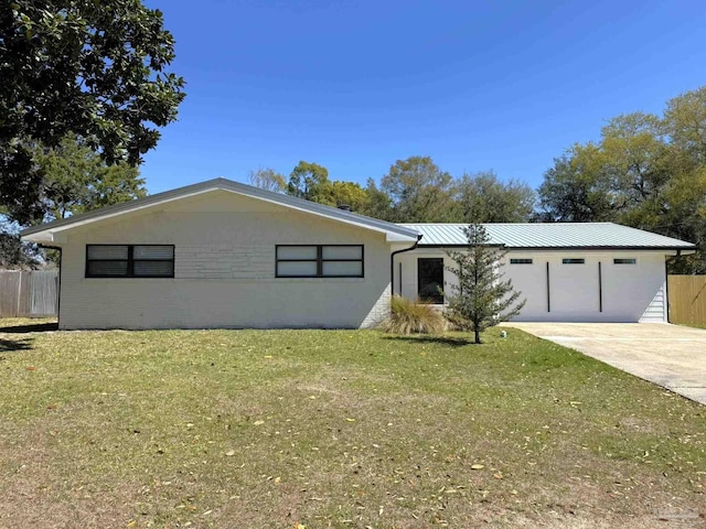 ranch-style home featuring concrete driveway, metal roof, fence, and a front lawn
