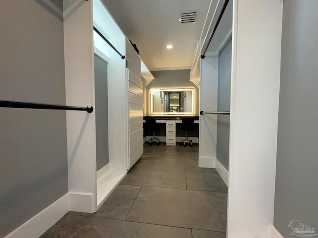 corridor with baseboards, dark tile patterned floors, visible vents, and recessed lighting