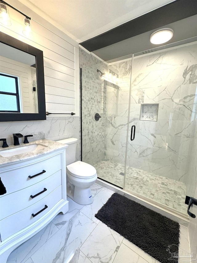 bathroom featuring a marble finish shower, toilet, marble finish floor, and vanity