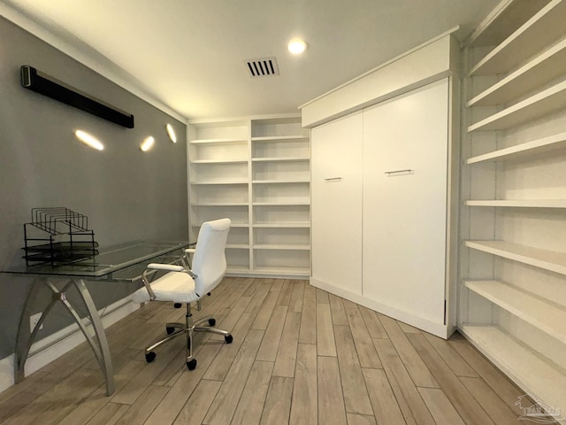 unfurnished office featuring visible vents and wood finished floors