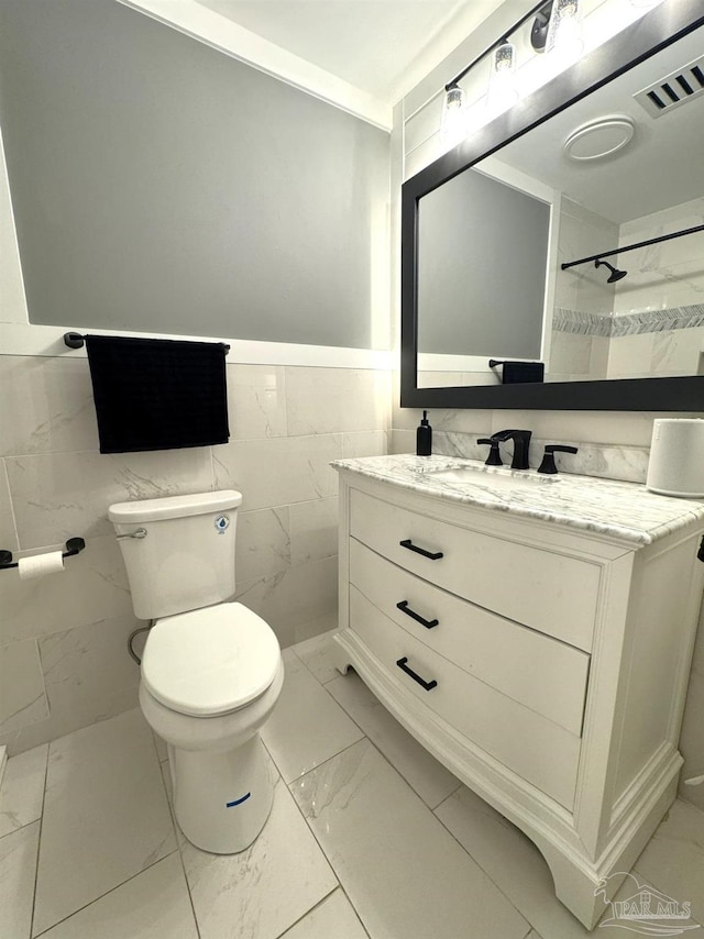 full bathroom featuring walk in shower, tile walls, toilet, vanity, and marble finish floor