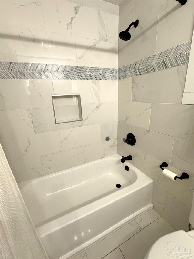 bathroom with shower / tub combo with curtain, marble finish floor, and toilet