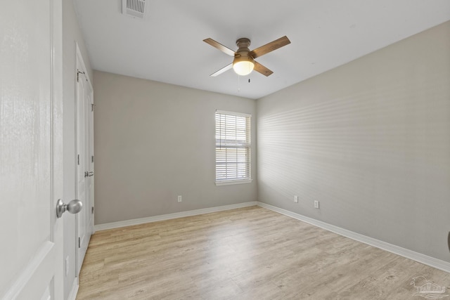 spare room featuring light wood-type flooring, visible vents, baseboards, and ceiling fan