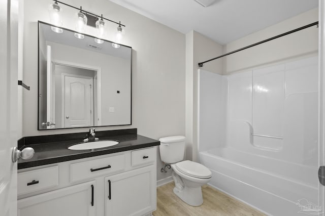 bathroom with vanity,  shower combination, toilet, and wood finished floors