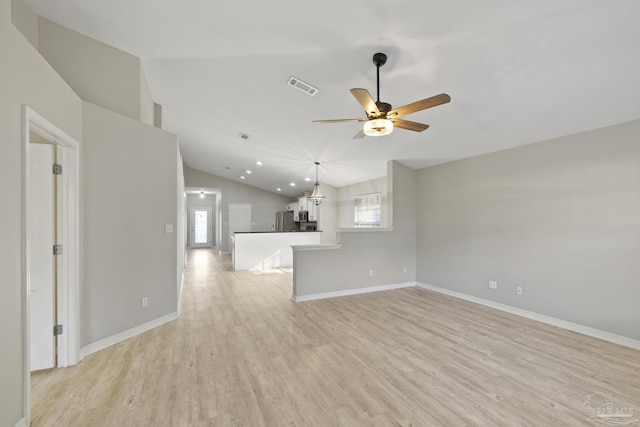 unfurnished living room with visible vents, light wood-style flooring, a ceiling fan, baseboards, and vaulted ceiling