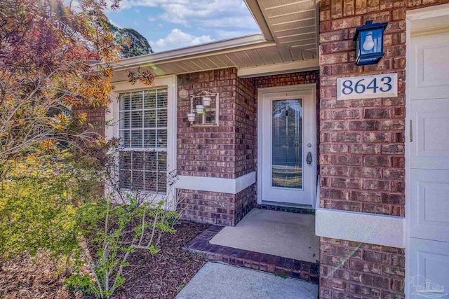 entrance to property with brick siding and a garage