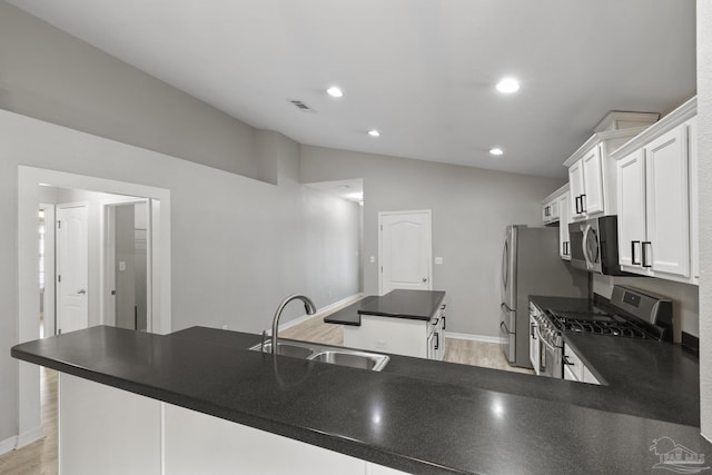 kitchen with a sink, a kitchen island, dark countertops, stainless steel appliances, and vaulted ceiling