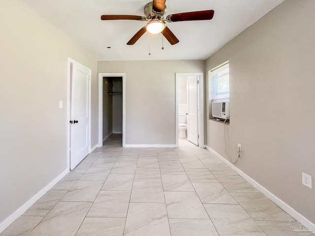 spare room featuring a ceiling fan, cooling unit, and baseboards