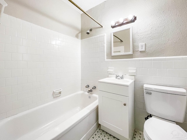 full bathroom featuring shower / bath combination, toilet, a wainscoted wall, vanity, and tile walls