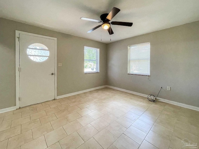 foyer entrance with baseboards, a ceiling fan, and light tile patterned flooring