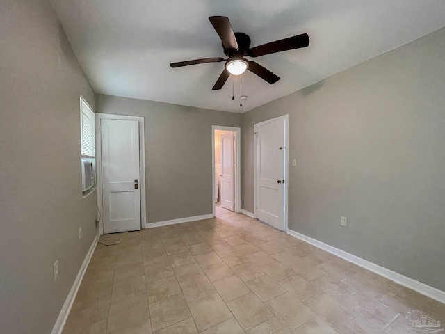 empty room with a ceiling fan and baseboards