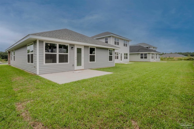 back of property with a patio, a lawn, and a shingled roof