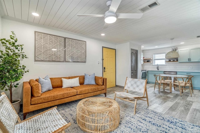 living room with wooden ceiling, sink, ornamental molding, ceiling fan, and light wood-type flooring