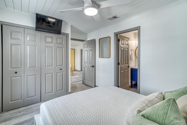 bedroom featuring light hardwood / wood-style floors, ensuite bathroom, ceiling fan, wood ceiling, and a closet