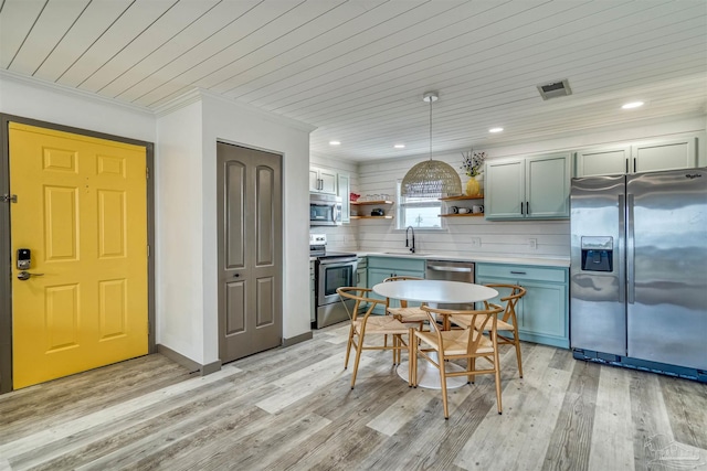 kitchen with sink, appliances with stainless steel finishes, decorative light fixtures, crown molding, and light wood-type flooring